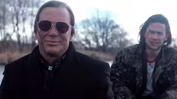 Armand Degas (Mickey Rourke) stands outdoors with Richie Nix (Joseph Gordon-Levitt) behind him