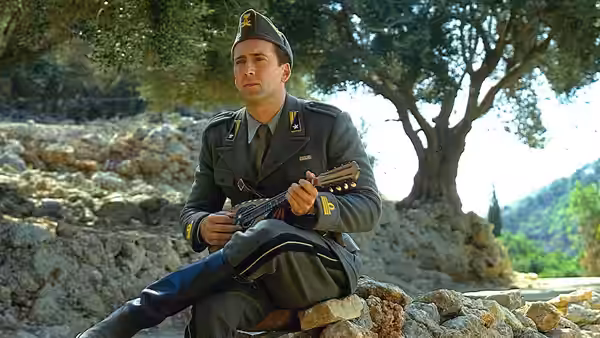Captain Antonio Corelli (Nicolas Cage) sits beneath a tree, holding his mandolin in uniform