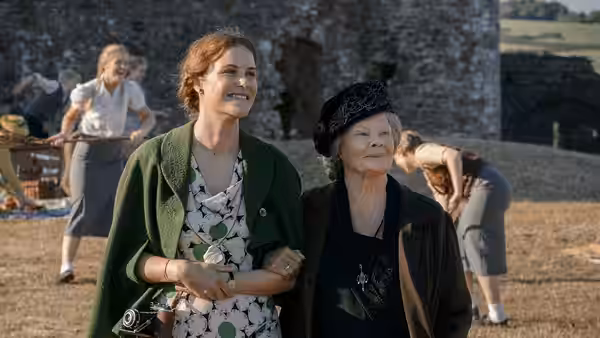 Ilse Keller (Carla Juri) walks arm in arm with Miss Rocholl (Judi Dench) outdoors