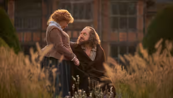 William Shakespeare (Kenneth Branagh) kneels beside Anne Shakespeare (Judi Dench) in a garden