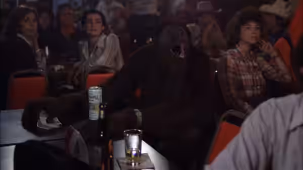 An orangutan sits among spectators in a crowded auditorium