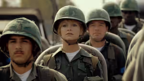 Judy Benjamin (Goldie Hawn) stands in formation with helmeted soldiers