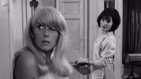 Carol Ledoux (Catherine Deneuve) looks back as Hélène Ledoux (Yvonne Furneaux) stands in the doorway