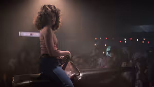 Sissy (Debra Winger) sits astride a mechanical bull before the watching crowd