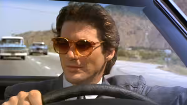 Julian Kaye (Richard Gere) drives along a desert highway wearing sunglasses