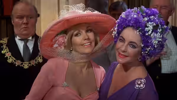Marina Rudd (Elizabeth Taylor) and Lola Brewster (Kim Novak) pose together in elaborate hats