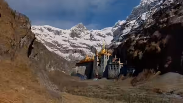 A fortress stands in a narrow mountain valley beneath snow-covered peaks