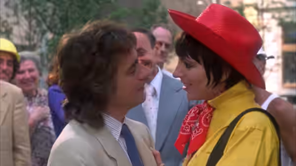 Arthur Bach (Dudley Moore) and Linda Marolla (Liza Minnelli) talk among wedding guests