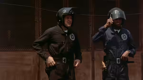Carey Mahoney (Steve Guttenberg) and Moses Hightower (Bubba Smith) stand in helmets and protective gear