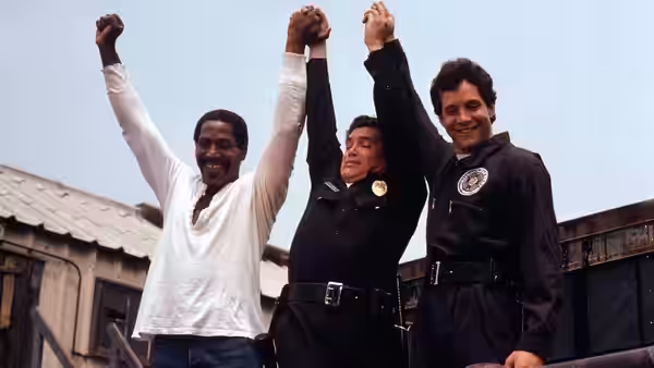 Moses Hightower (Bubba Smith) and Carey Mahoney (Steve Guttenberg) raise their joined hands in celebration