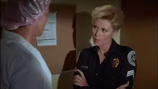 Sergeant Callahan (Leslie Easterbrook) speaks with a cadet in an office