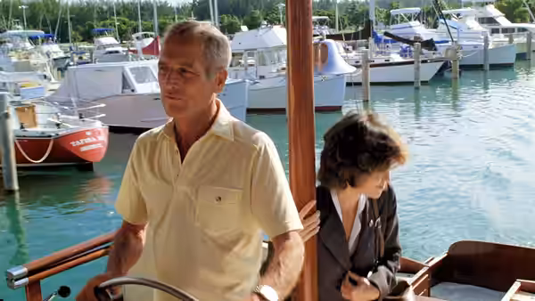Michael Colin Gallagher (Paul Newman) steers a boat while Megan Carter (Sally Field) sits nearby