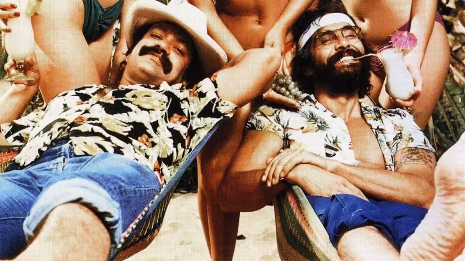 Cheech (Cheech Marin) and Chong (Tommy Chong) recline in deck chairs among women