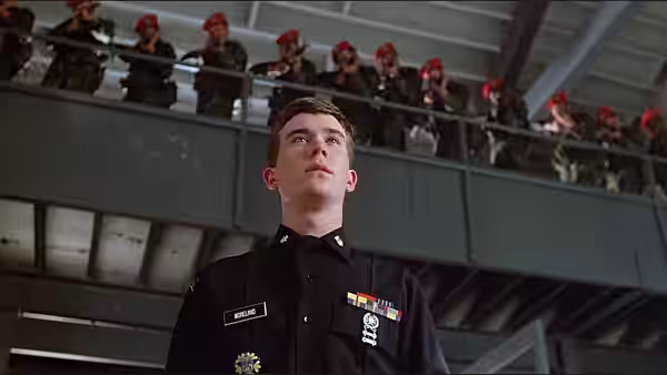 Cadet Major Brian Moreland (Timothy Hutton) stands beneath cadets watching from an upper balcony