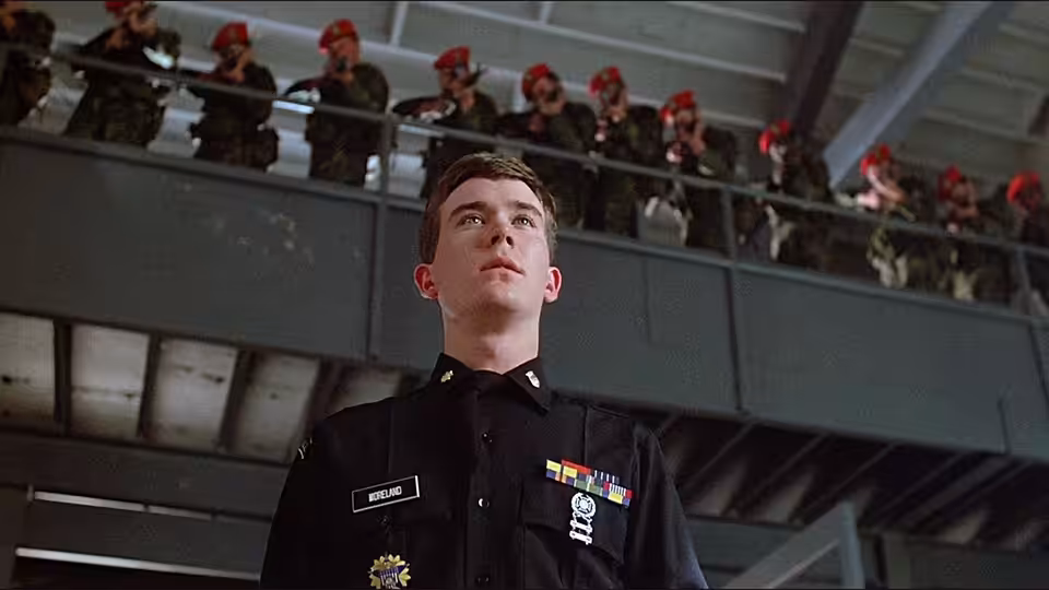 Cadet Major Brian Moreland (Timothy Hutton) stands beneath cadets watching from an upper balcony