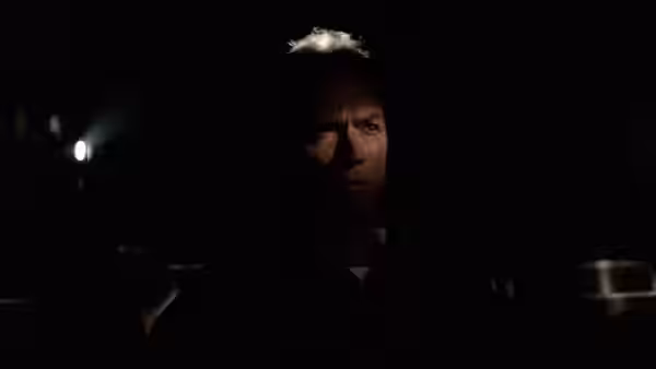 Mitchell Gant (Clint Eastwood) sits in a dark interior