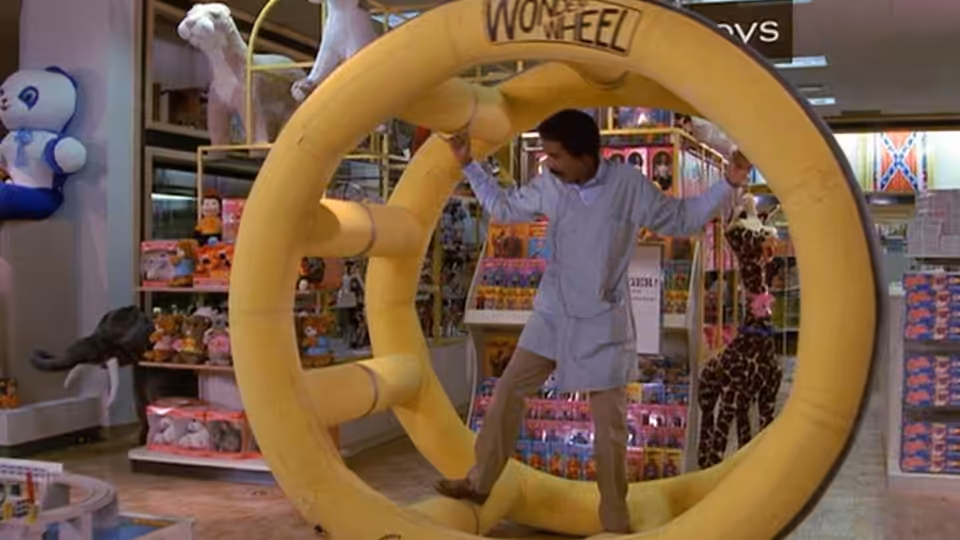 Jack Brown (Richard Pryor) stands inside a giant yellow toy wheel in a toy store