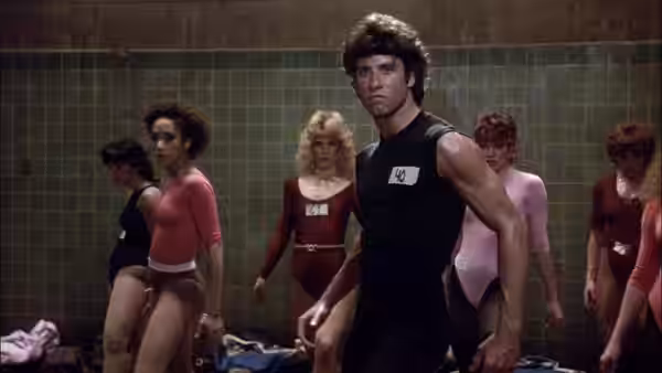 Tony Manero stands among dancers during an audition