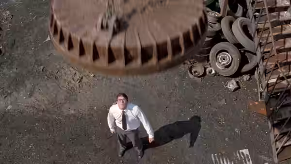Clark Kent (Christopher Reeve) looks up as a massive metal object descends in a scrapyard
