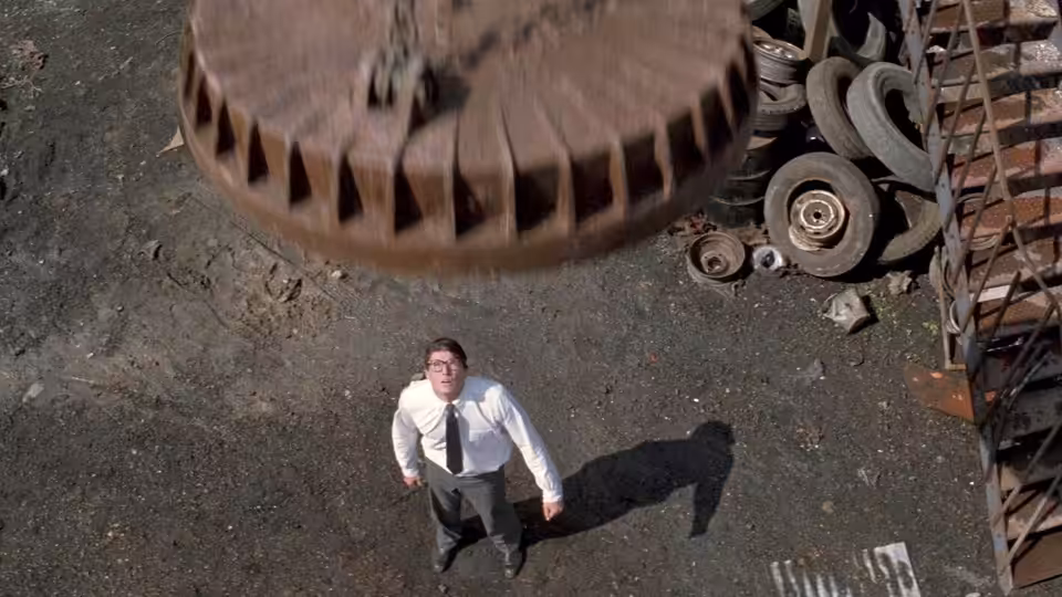 Clark Kent (Christopher Reeve) looks up as a massive metal object descends in a scrapyard
