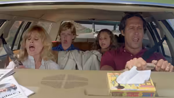 Clark and Ellen Griswold drive with their children singing inside the station wagon