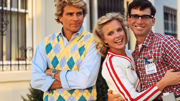 Stan Gable (Ted McGinley) stands beside Betty Childs (Julia Montgomery), who embraces Lewis Skolnick (Robert Carradine)
