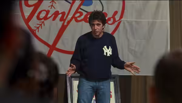 Frank Keller (Al Pacino) addresses an audience in a Yankees sweatshirt