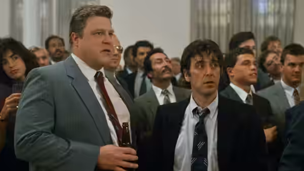 Sherman (John Goodman) and Frank Keller (Al Pacino) stand among men at a gathering