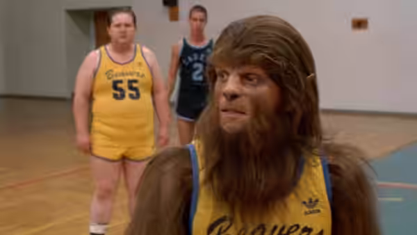 Scott Howard (Michael J. Fox), transformed into a werewolf, stands on a basketball court with teammates