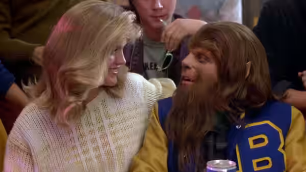 Scott Howard (Michael J. Fox), transformed into a werewolf, talks with a blonde woman at a crowded gathering