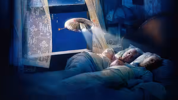 An illuminated miniature spacecraft floats through an open window above a sleeping couple