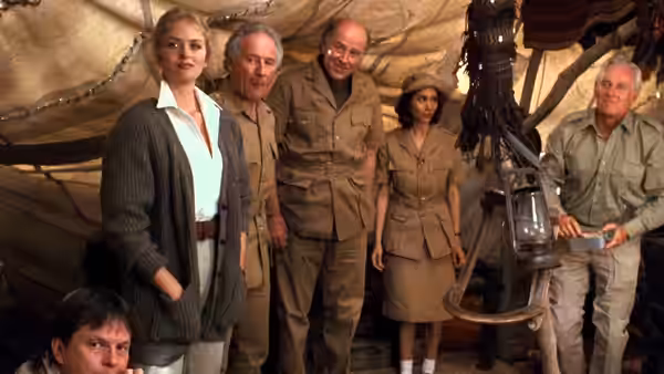 Karen Boyer (Donna Dixon) stands with several men inside a canvas tent