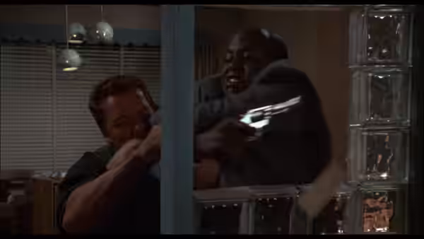 John Matrix (Arnold Schwarzenegger) grapples with Cooke (Bill Duke) inside a house