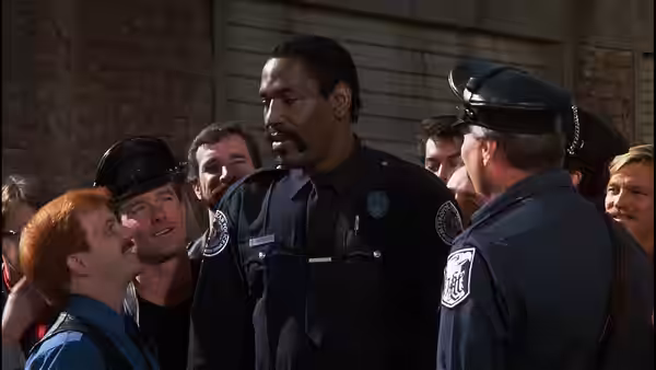 Moses Hightower (Bubba Smith) stands surrounded by fellow officers outside a building