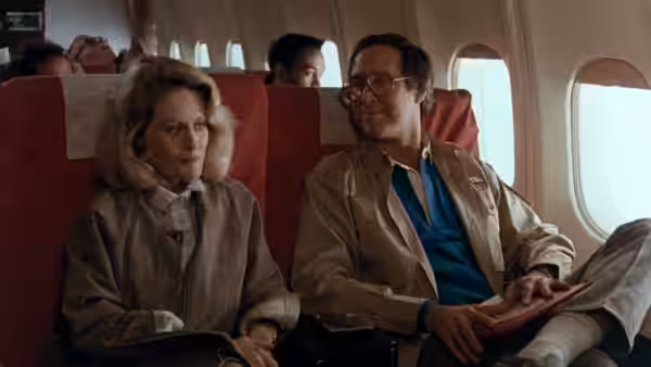 Ellen (Beverly D'Angelo) and Clark (Chevy Chase) sit together aboard an airplane
