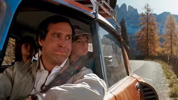 Clark (Chevy Chase) drives the family station wagon along a mountain road