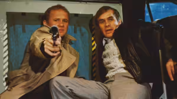 Col. Tom Carlsen (Steve Railsback) aims a pistol beside a startled man in a vehicle
