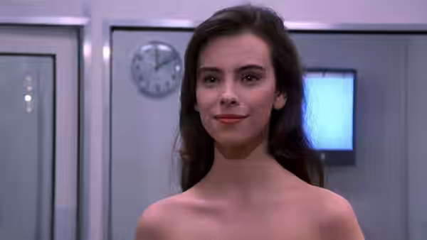 The Space Girl (Mathilda May) stands in a control room, smiling