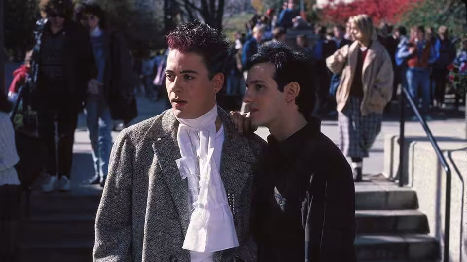 Jason Melon (Keith Gordon) stands with a fellow student on the college steps
