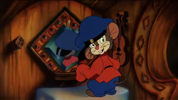 Fievel Mousekewitz (Phillip Glasser) sits smiling on a stool inside a wooden room