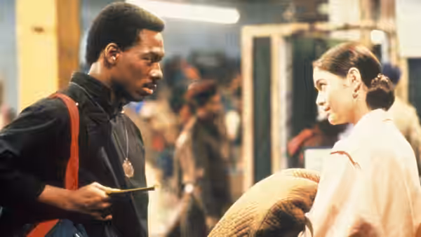 Chandler Jarrell (Eddie Murphy) speaks with Kee Nang (Charlotte Lewis) in a crowded market