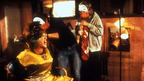 Barbara Stone (Bette Midler) sits bound in a chair as masked kidnappers loom over her