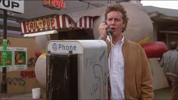 Ken Kessler (Judge Reinhold) speaks on a pay phone outside a storefront