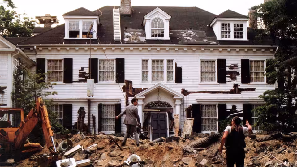 Walter Fielding and workers stand amid rubble before the dilapidated house