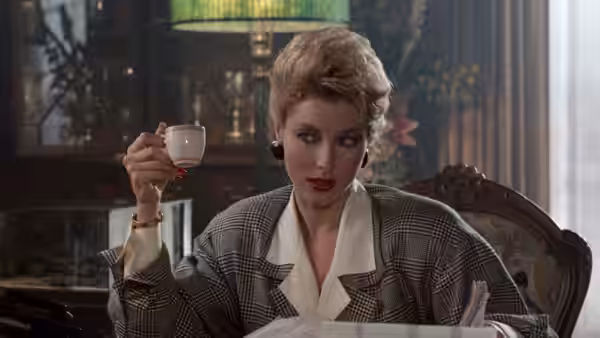 Karla Fry raises a teacup while seated at a table