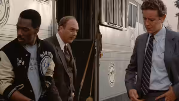 Axel Foley, Billy Rosewood and John Taggart walk between parked trailers