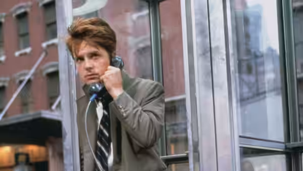 Brantley Foster (Michael J. Fox) talks on a payphone beside a city street