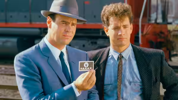 Sgt. Joe Friday (Dan Aykroyd) displays his badge beside Pep Streebeck (Tom Hanks) near a truck