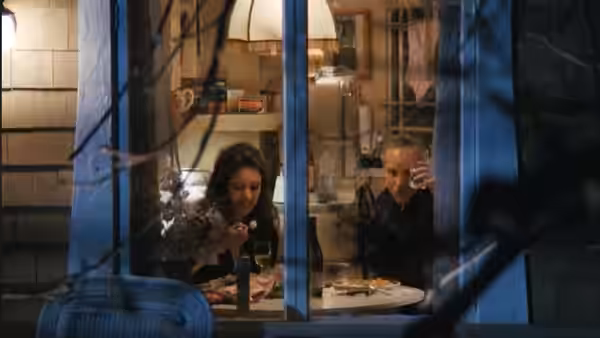 Chris Lecce (Richard Dreyfuss) and Maria McGuire (Madeleine Stowe) dine at a table, seen through a window