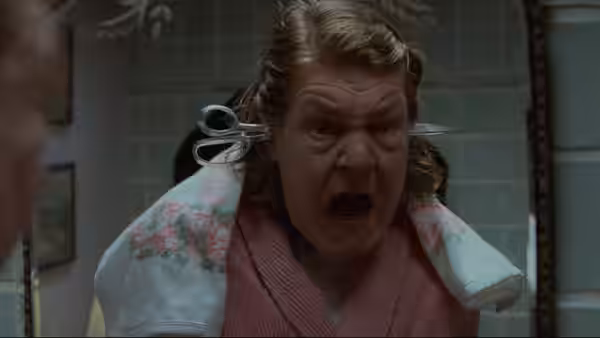 Mrs. Lift (Anne Ramsey) shouts in a bathroom with scissors caught in her hair